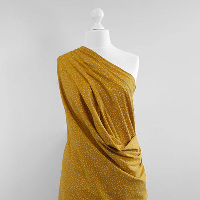 Arizona - Mustard Yellow Ticker Tape, Single Jersey Cotton Elastane Print Fabric Mannequin Wide Image from Patternsandplains.com