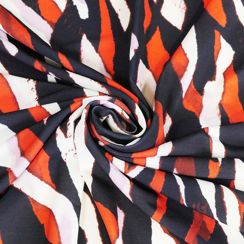 Portia - Navy and Orange Fracture Stretch Jersey Fabric from John Kaldor Detail Swirl Image from Patternsandplains.com