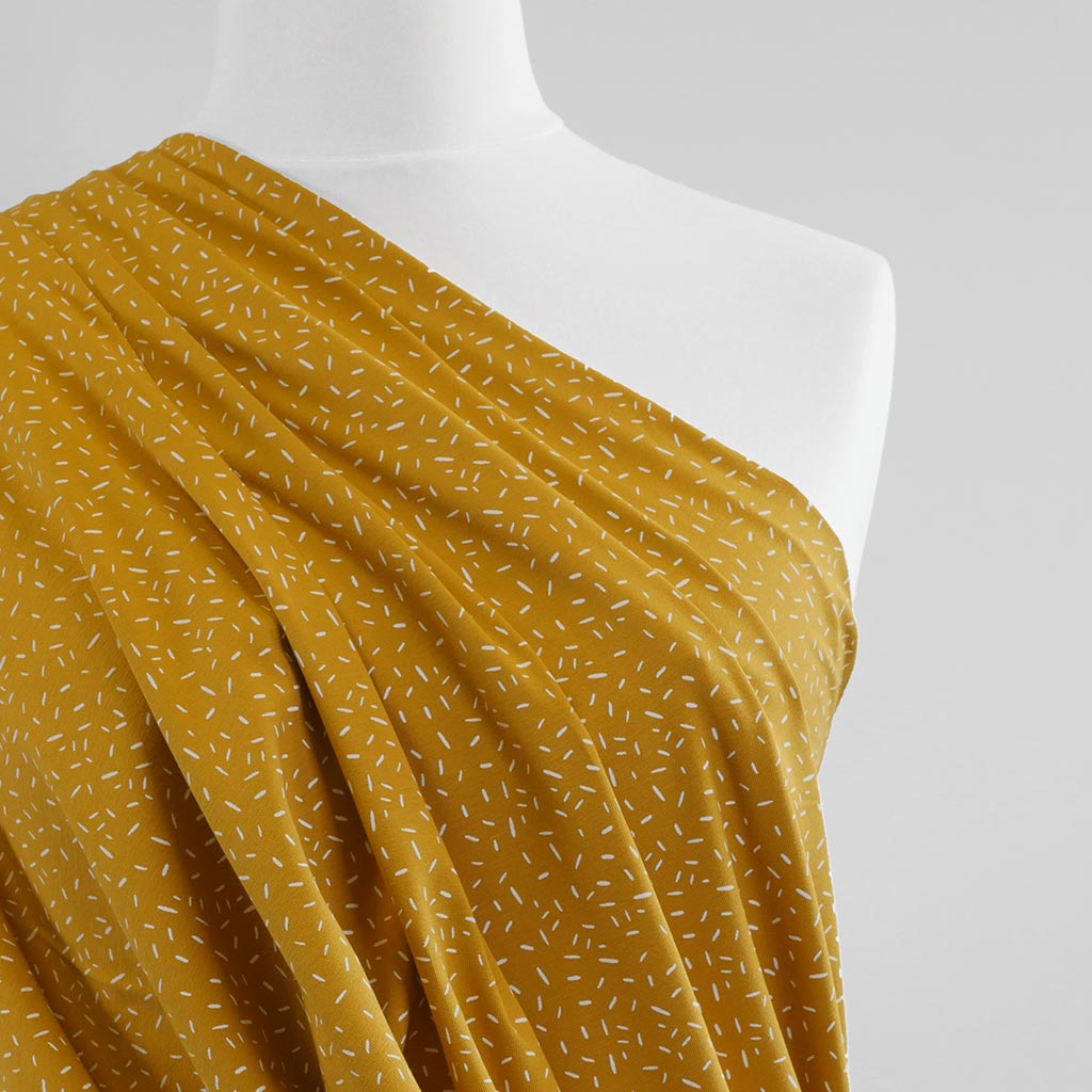 Arizona - Mustard Yellow Ticker Tape, Single Jersey Cotton Elastane Print Fabric Mannequin Close Up Image from Patternsandplains.com